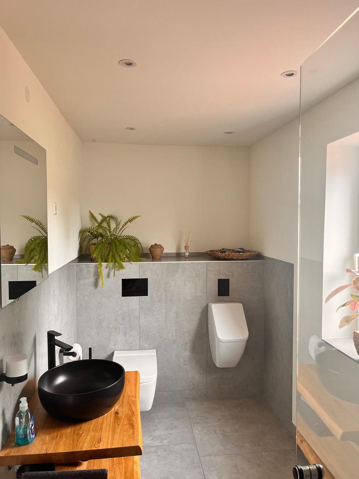 Gäste-WC mit grauen Fliesen und Urinal